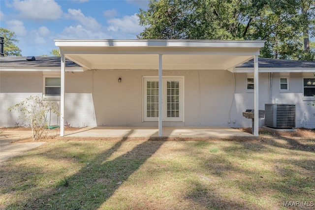 rear view of house featuring a patio, central AC unit, and a yard