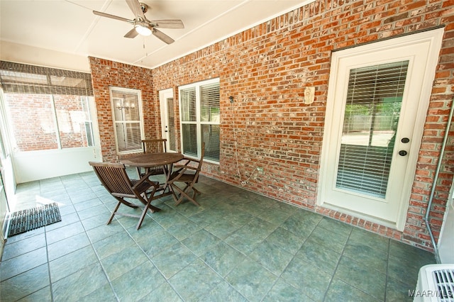 unfurnished sunroom featuring ceiling fan and plenty of natural light