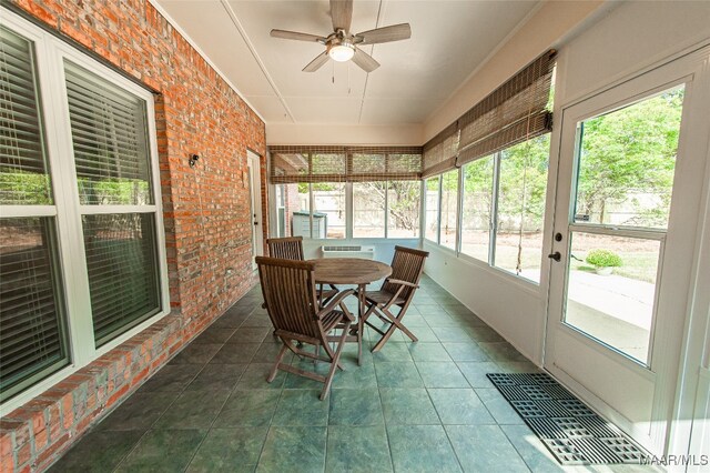 sunroom with a healthy amount of sunlight and ceiling fan