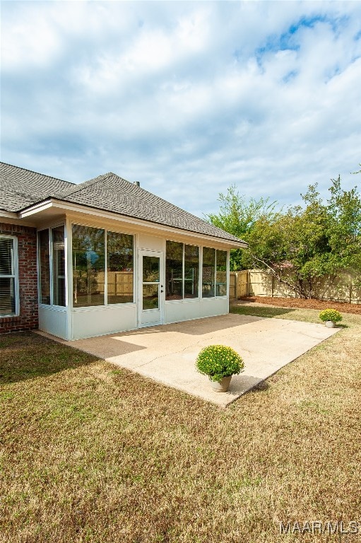 rear view of property with a yard and a patio area