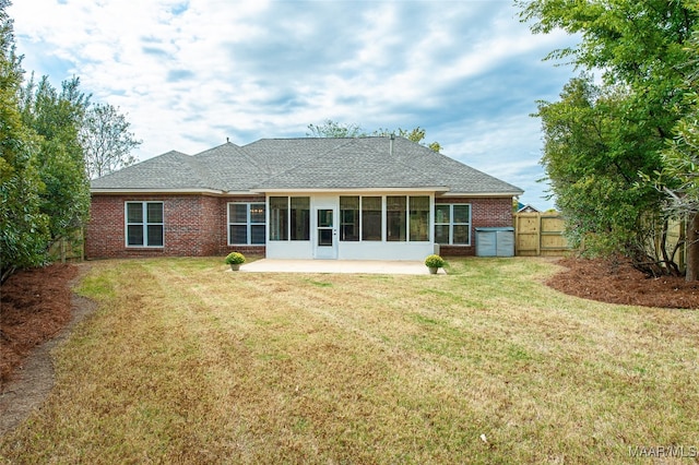 back of property with a lawn and a sunroom