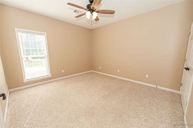 spare room with ceiling fan and light colored carpet