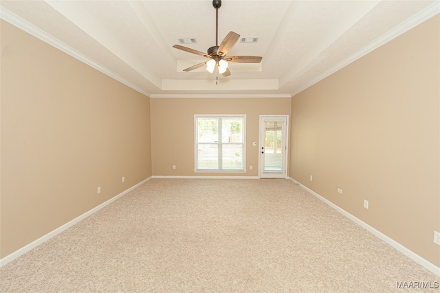 carpeted empty room with ornamental molding, ceiling fan, and a raised ceiling