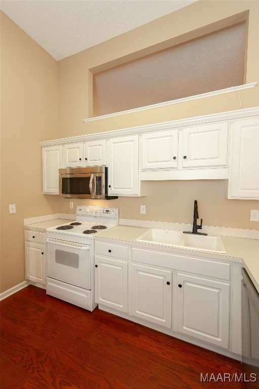 kitchen with white cabinets, sink, dark wood-type flooring, and white appliances