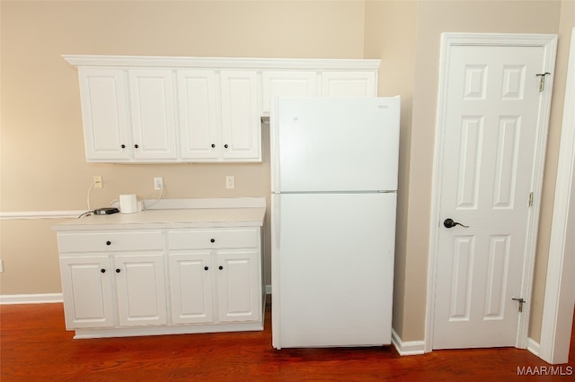 kitchen with white cabinets, white fridge, and dark hardwood / wood-style flooring