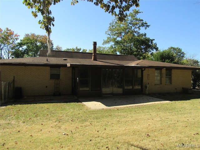 rear view of property featuring a yard and a patio area