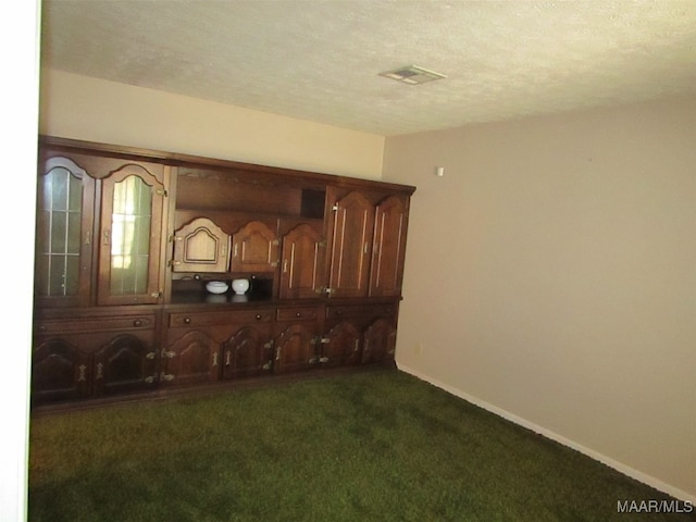 interior space with dark carpet and a textured ceiling