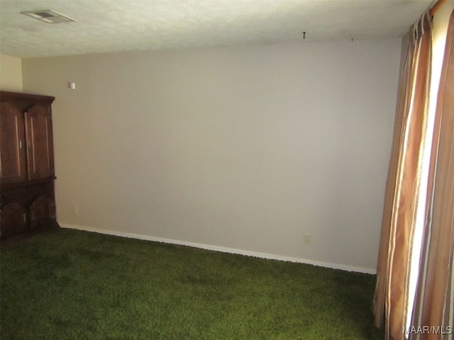 carpeted empty room with a textured ceiling