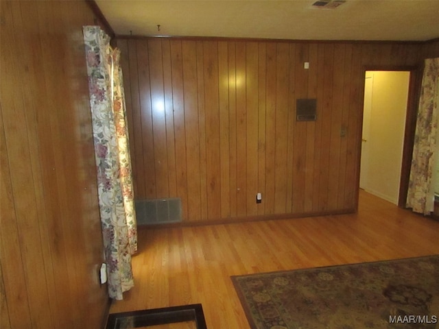 unfurnished room featuring hardwood / wood-style floors and wooden walls