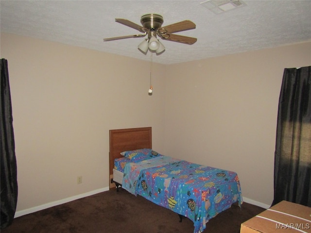 bedroom featuring ceiling fan, a textured ceiling, and dark carpet