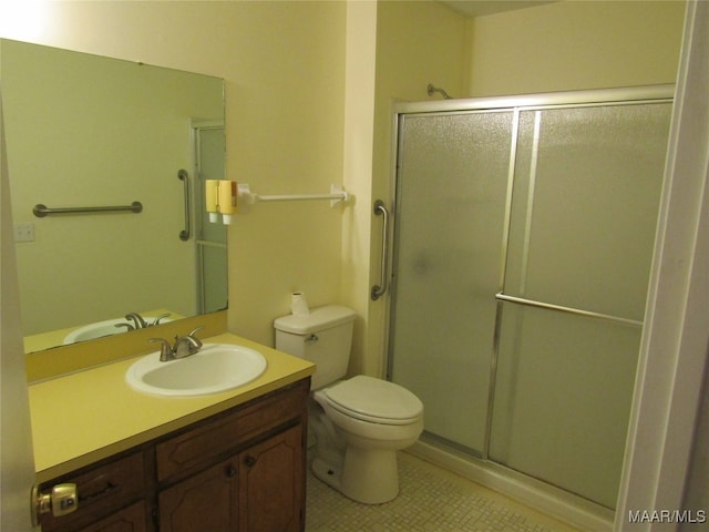 bathroom featuring vanity, toilet, tile patterned floors, and an enclosed shower