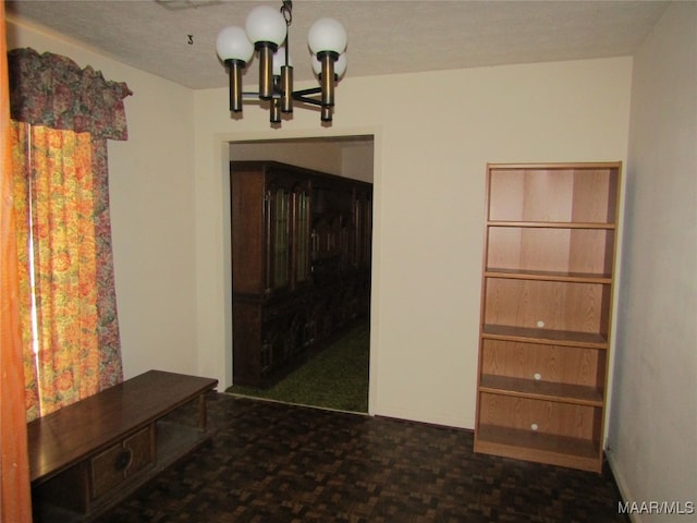 unfurnished dining area featuring a notable chandelier and a textured ceiling