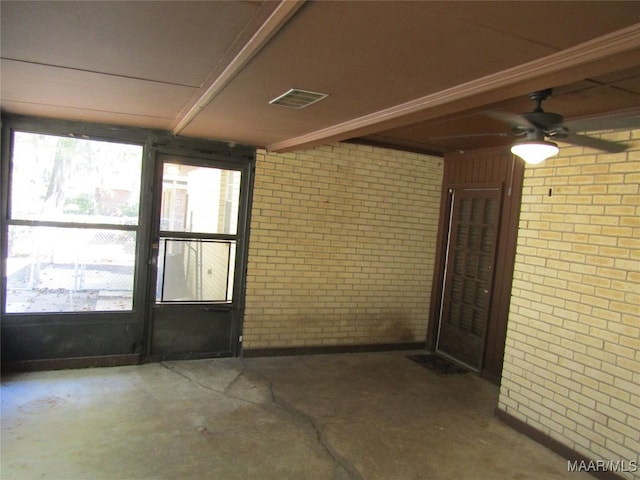 interior space featuring brick wall and ceiling fan