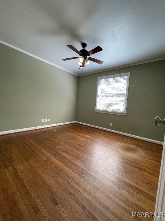 spare room featuring crown molding, wood-type flooring, and ceiling fan