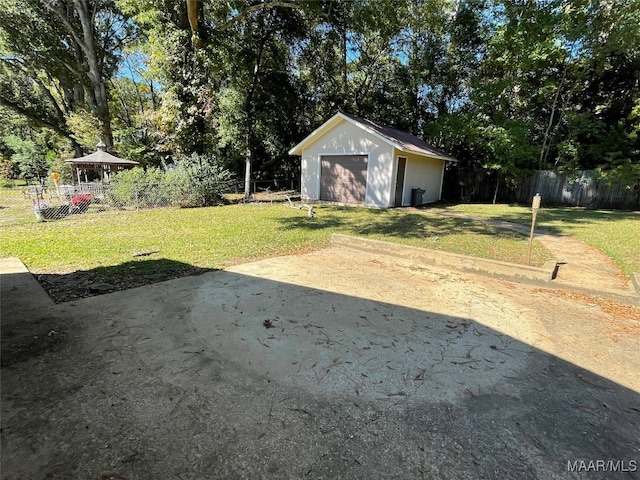 view of yard featuring a garage and an outbuilding