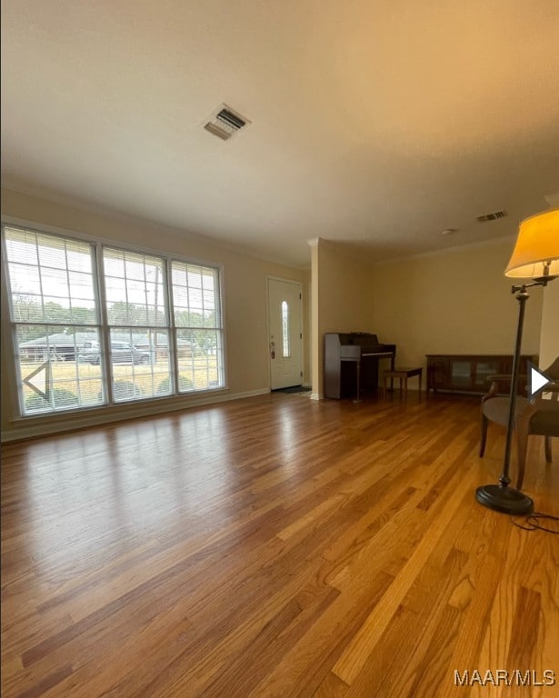 unfurnished living room featuring hardwood / wood-style flooring and a healthy amount of sunlight