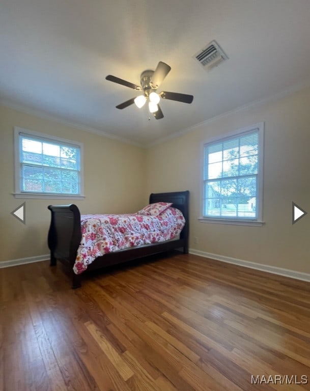 bedroom with ceiling fan, hardwood / wood-style flooring, and ornamental molding