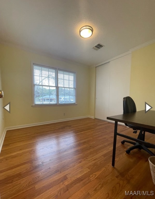 office space featuring wood-type flooring and ornamental molding