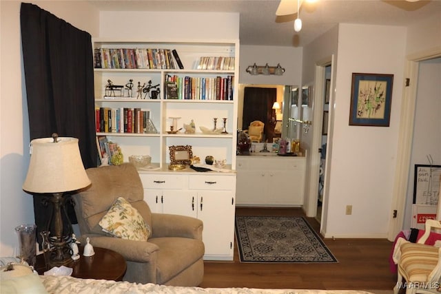 living area with ceiling fan and dark hardwood / wood-style flooring