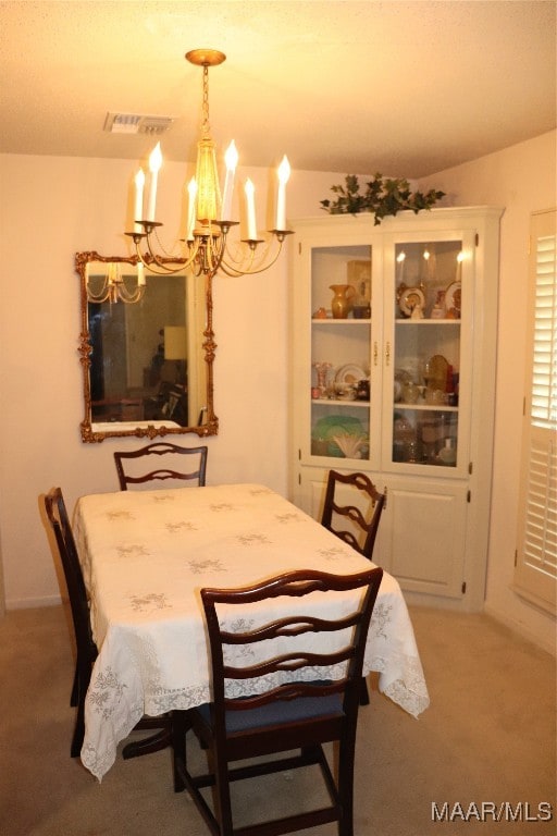 dining room with carpet and an inviting chandelier