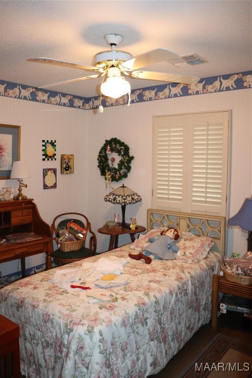 bedroom with a textured ceiling and ceiling fan