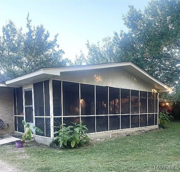 view of side of property featuring a yard and a sunroom