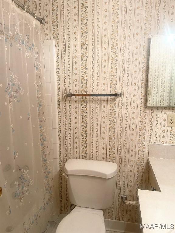 bathroom featuring a shower with curtain and toilet