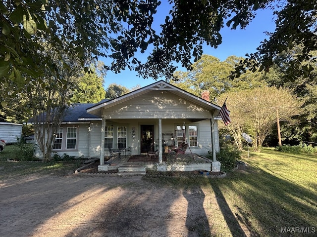 bungalow with covered porch and a front yard