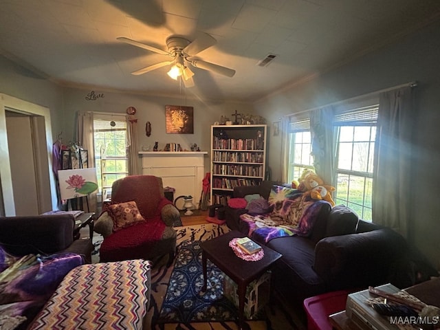 living room with hardwood / wood-style floors, ceiling fan, and crown molding