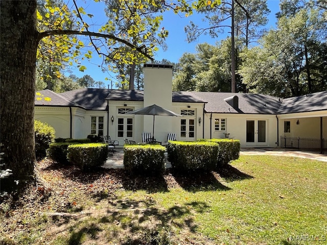 back of house with french doors and a lawn