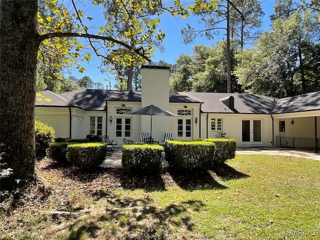 rear view of house featuring french doors and a yard