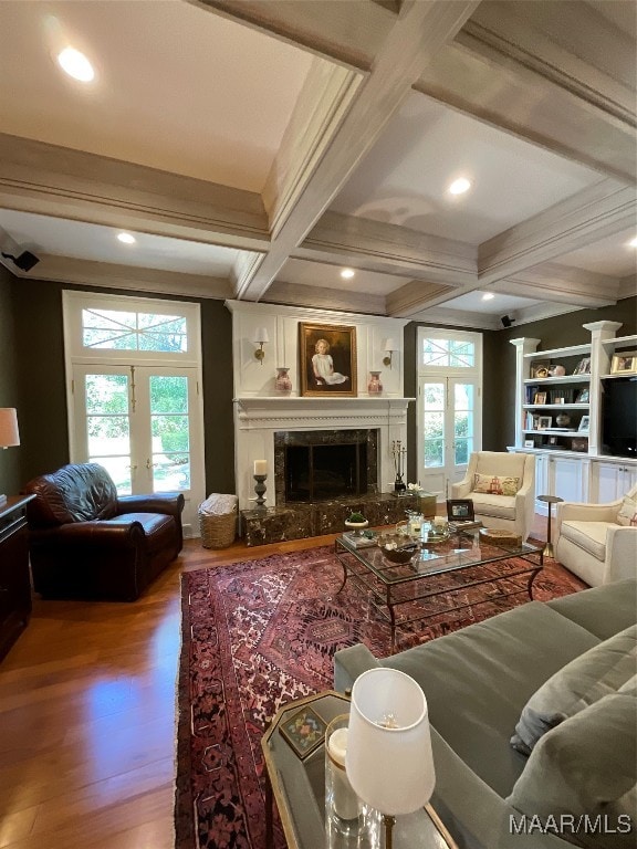 living room featuring a high end fireplace, hardwood / wood-style flooring, beamed ceiling, and a wealth of natural light