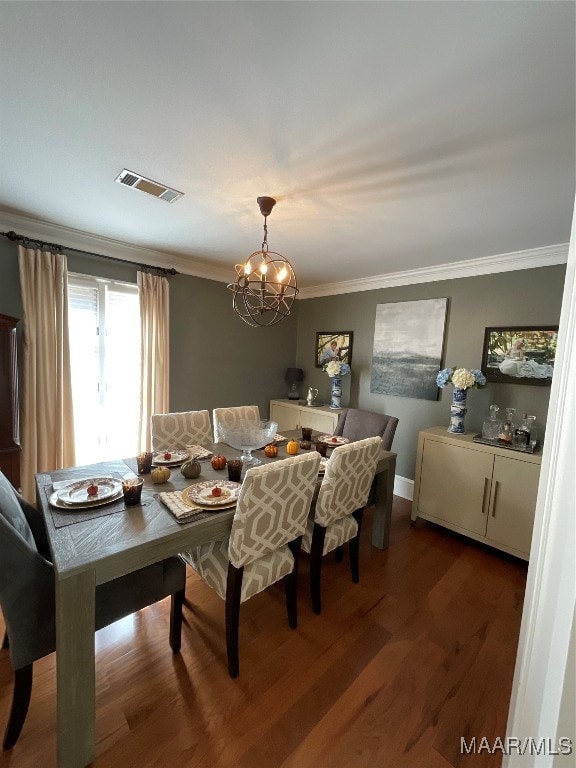 dining area with ornamental molding, a notable chandelier, and dark hardwood / wood-style floors