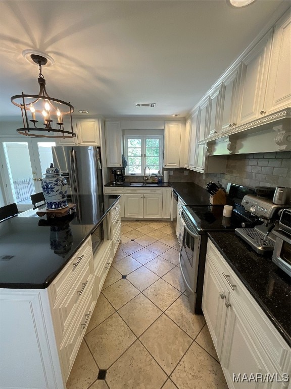 kitchen featuring white cabinets, light tile patterned floors, appliances with stainless steel finishes, backsplash, and pendant lighting