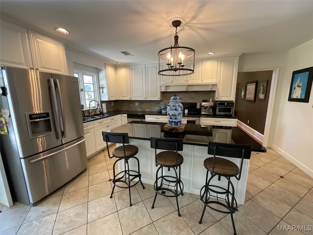 kitchen with a kitchen breakfast bar, white cabinets, and stainless steel appliances