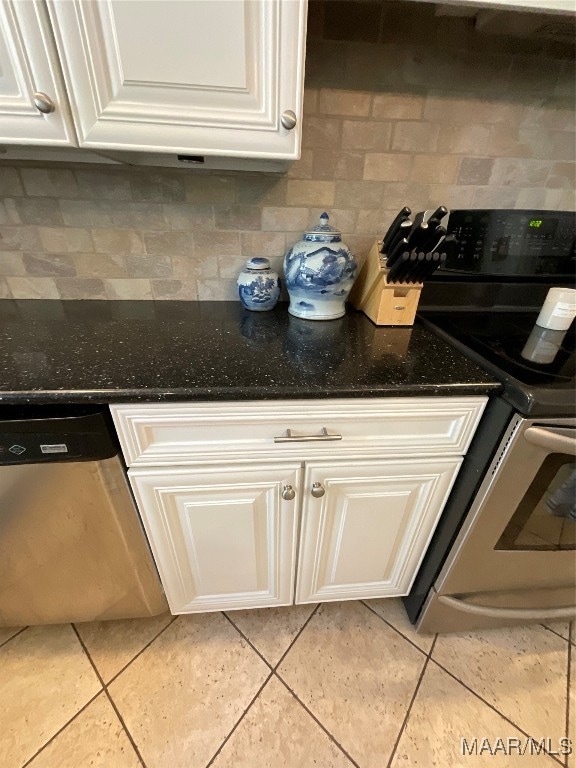 kitchen with white cabinets, tasteful backsplash, stainless steel appliances, and light tile patterned floors