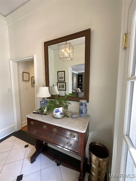 bathroom with crown molding, a chandelier, and tile patterned flooring