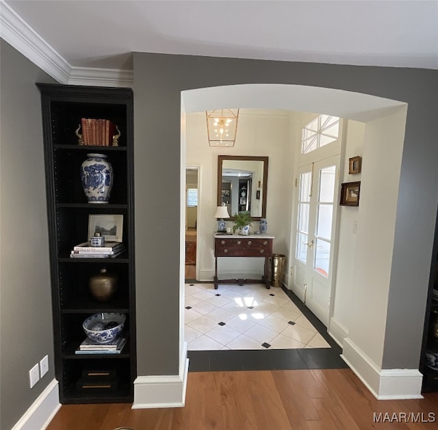 doorway to outside featuring french doors, crown molding, an inviting chandelier, and hardwood / wood-style floors