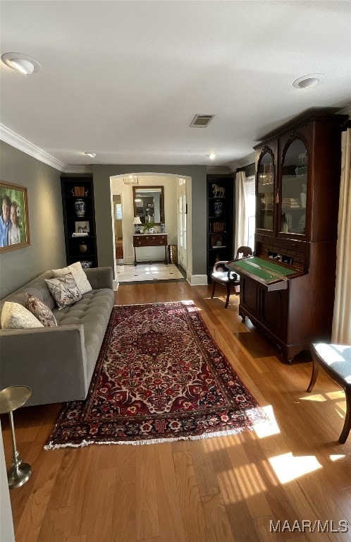 living room featuring light hardwood / wood-style flooring and ornamental molding