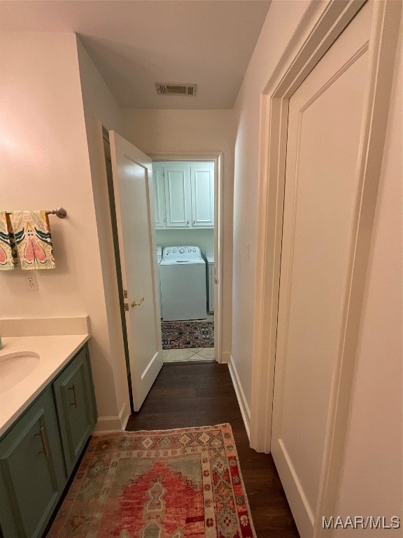 bathroom with vanity, hardwood / wood-style flooring, and separate washer and dryer