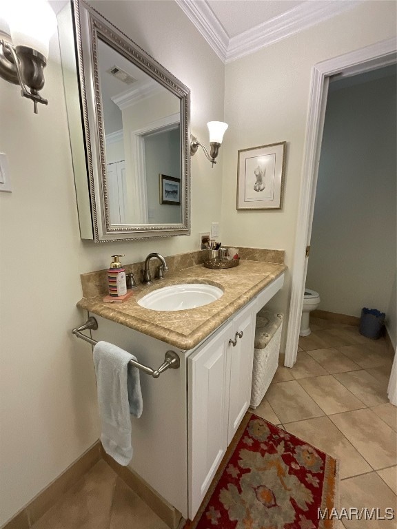 bathroom featuring vanity, toilet, ornamental molding, and tile patterned flooring