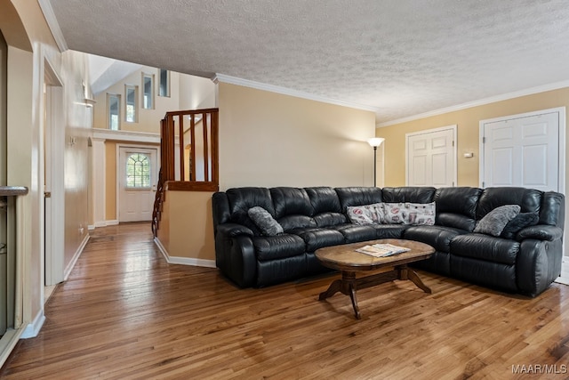 living room featuring ornamental molding, hardwood / wood-style floors, and a textured ceiling