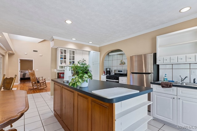 kitchen featuring white cabinetry, light tile patterned floors, appliances with stainless steel finishes, and a center island