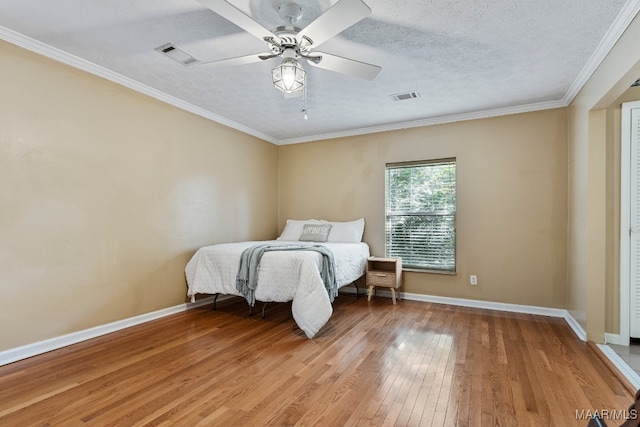 bedroom with ornamental molding, a textured ceiling, hardwood / wood-style flooring, and ceiling fan