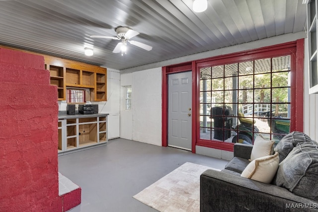 living room featuring ceiling fan and concrete flooring