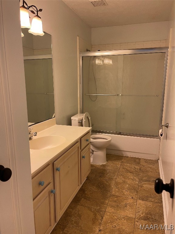 full bathroom with vanity, combined bath / shower with glass door, and toilet