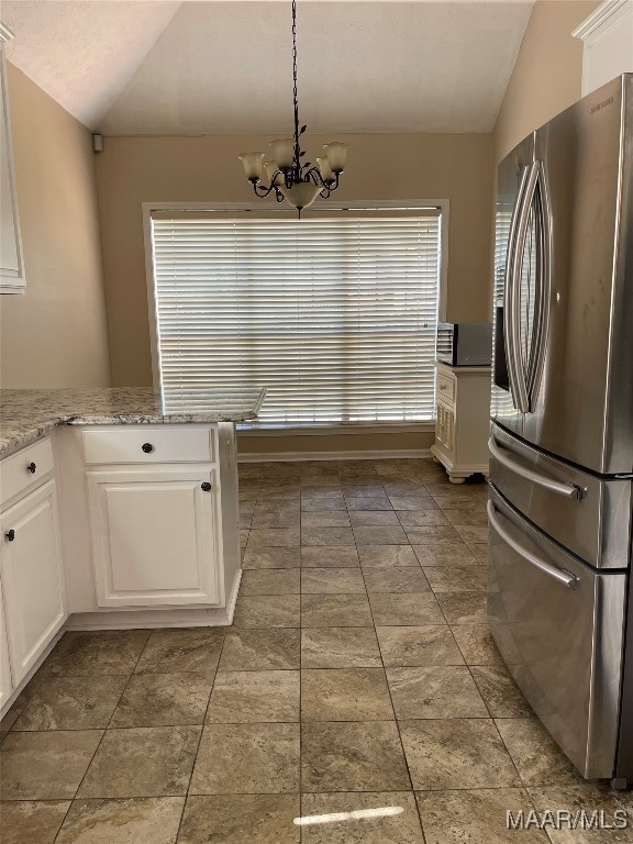 kitchen with vaulted ceiling, stainless steel fridge with ice dispenser, and white cabinets