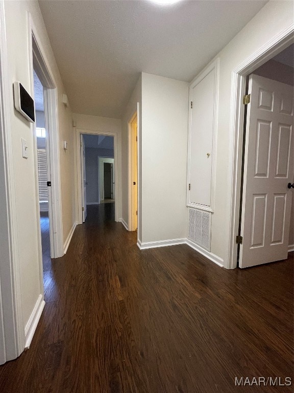 hallway with dark hardwood / wood-style flooring