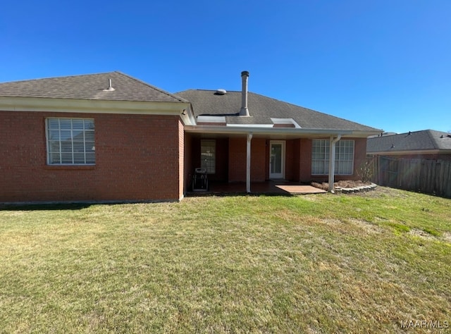 rear view of property featuring a yard and a patio