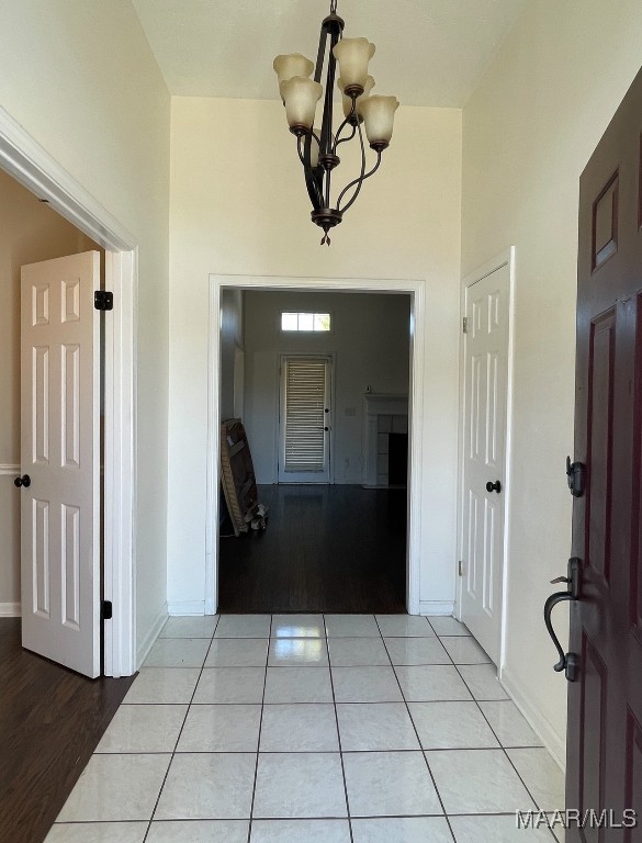 tiled entrance foyer featuring a chandelier